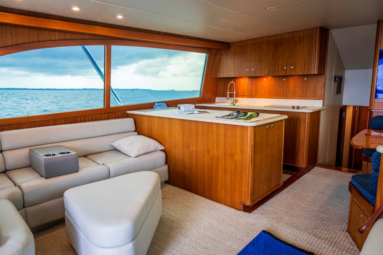 Spacious and elegantly designed yacht interior showcasing wooden furnishings and ocean view.